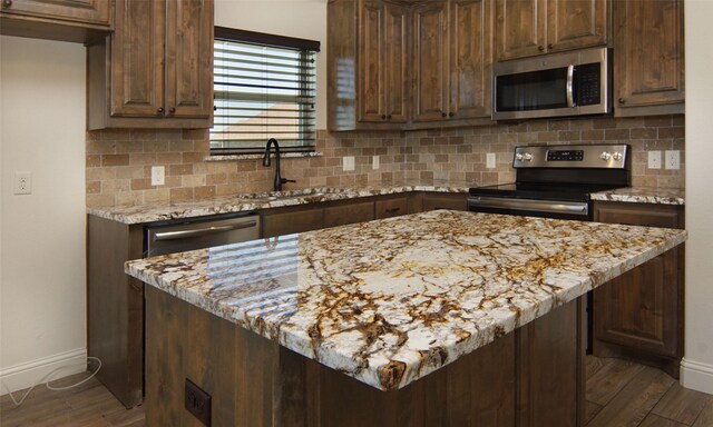 217 Timber Valley Ct, Weatherford, TX 76085 - kitchen with stainless steel appliances, a sink, baseboards, dark wood-style flooring, and backsplash