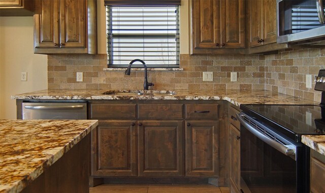 217 Timber Valley Ct, Weatherford, TX 76085 - kitchen with appliances with stainless steel finishes, a sink, tasteful backsplash, and light stone countertops