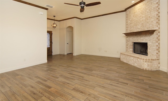 217 Timber Valley Ct, Weatherford, TX 76085 - unfurnished living room featuring ceiling fan, wood finished floors, baseboards, ornamental molding, and arched walkways