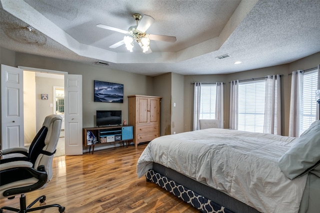 bedroom with a textured ceiling, multiple windows, and visible vents