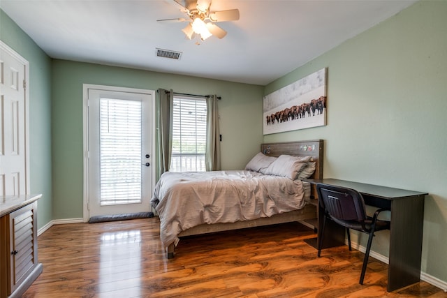 bedroom featuring multiple windows, visible vents, baseboards, and access to exterior