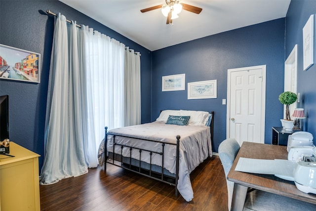 bedroom with a textured wall, wood finished floors, and ceiling fan