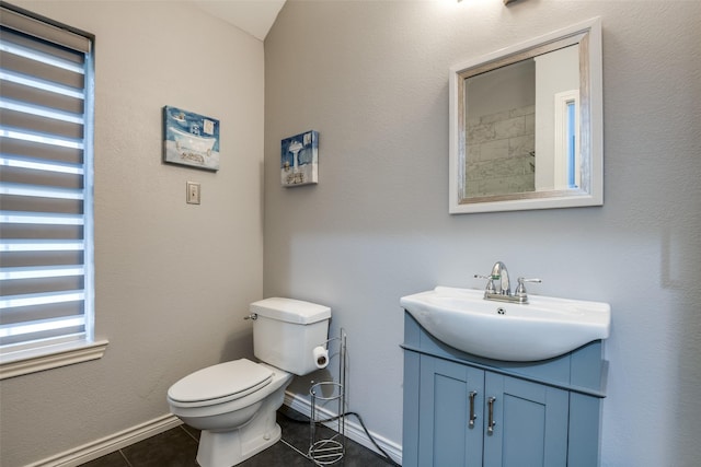 bathroom featuring baseboards, vanity, tile patterned flooring, and toilet
