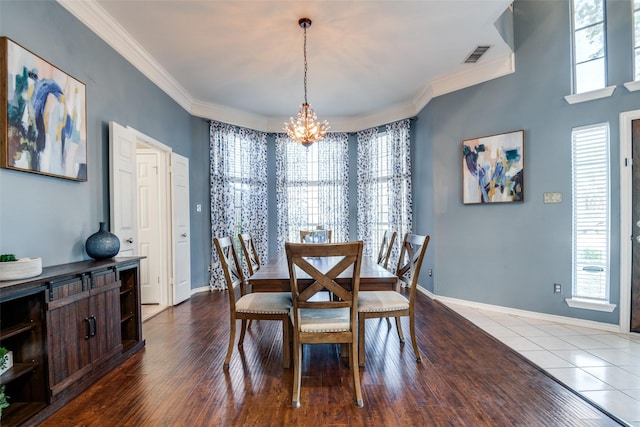 dining area with a wealth of natural light, a notable chandelier, crown molding, and visible vents