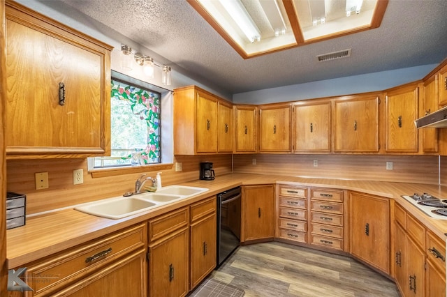 kitchen featuring light countertops, dishwasher, white electric cooktop, and a sink