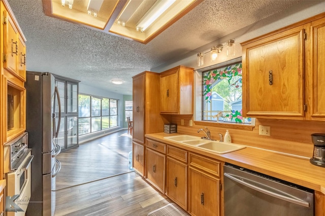 kitchen featuring stainless steel appliances, light countertops, a sink, and a textured ceiling