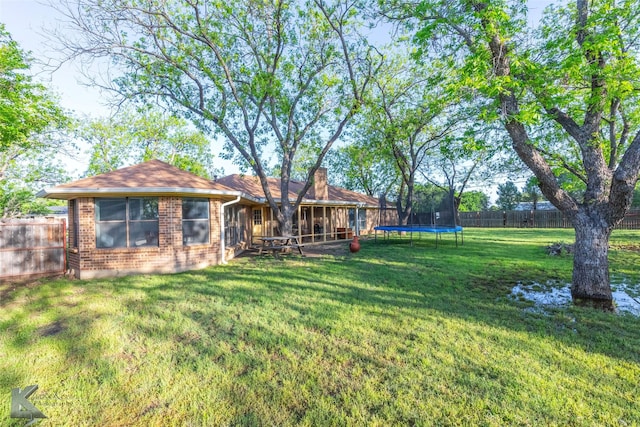 view of yard featuring a fenced backyard and a trampoline