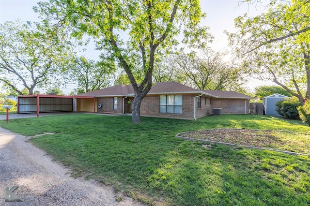 exterior space with fence, a storage shed, cooling unit, brick siding, and a front yard