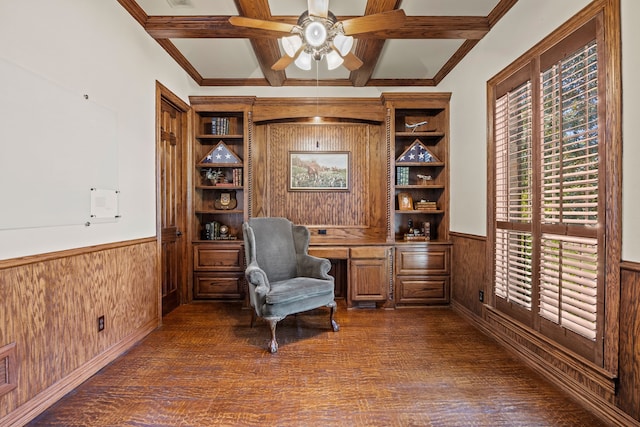 living area with a wainscoted wall, wooden walls, a ceiling fan, and dark wood finished floors