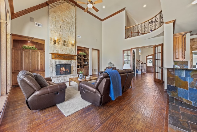 living area with a ceiling fan, a fireplace, ornamental molding, and high vaulted ceiling