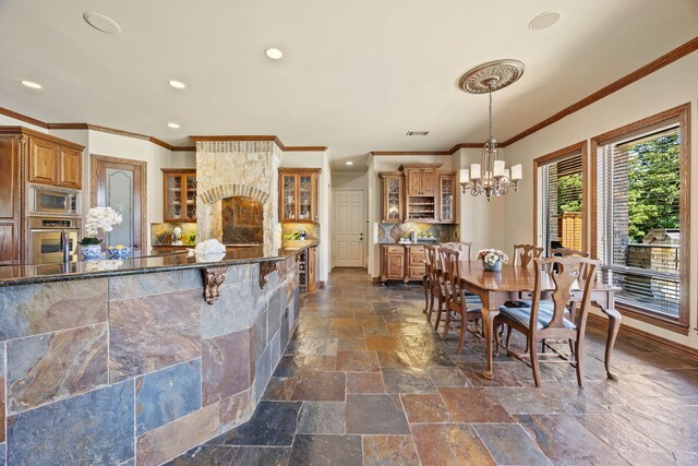 dining area featuring a chandelier, stone tile flooring, ornamental molding, visible vents, and recessed lighting
