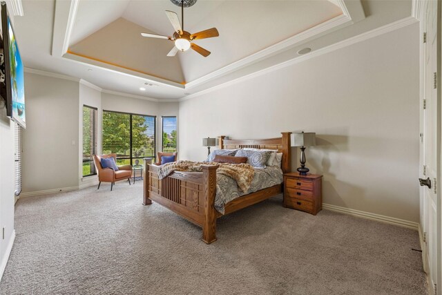 carpeted bedroom with ornamental molding, a ceiling fan, baseboards, and a raised ceiling