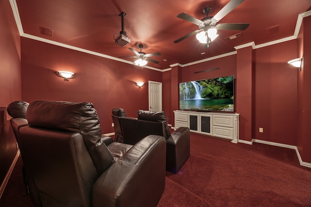 home theater featuring crown molding, ceiling fan, baseboards, dark colored carpet, and visible vents