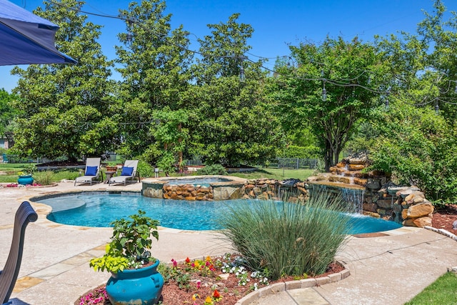 view of pool featuring fence, a patio area, and a pool with connected hot tub
