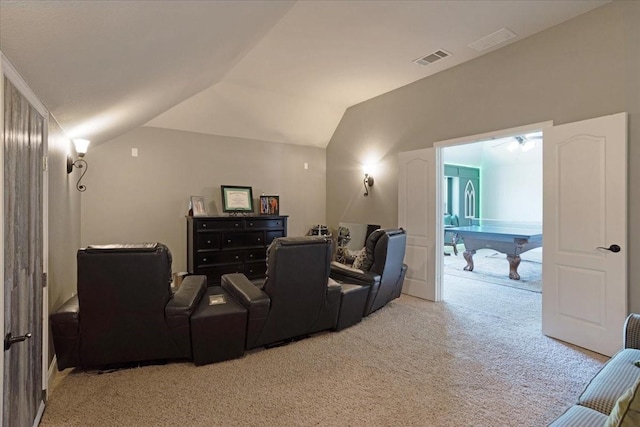 home theater with light colored carpet, vaulted ceiling, and visible vents