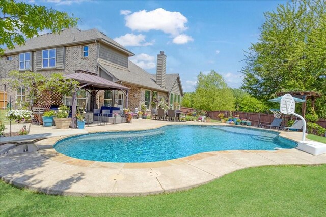 view of swimming pool with fence, a patio area, a fenced in pool, and a gazebo