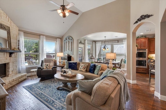 living area featuring arched walkways, a wealth of natural light, high vaulted ceiling, and ceiling fan