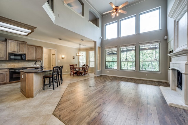 103 Lakehill Ct, Hickory Creek, TX 75065 - kitchen with oven, black microwave, dark countertops, ornamental molding, and a fireplace with raised hearth