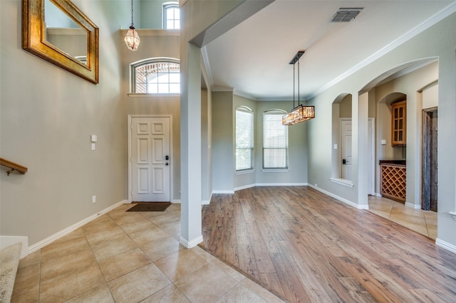 103 Lakehill Ct, Hickory Creek, TX 75065 - entryway with ornamental molding, wood finished floors, a chandelier, baseboards, and arched walkways