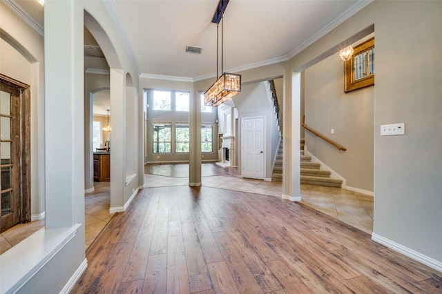 103 Lakehill Ct, Hickory Creek, TX 75065 - entryway featuring light wood-type flooring, arched walkways, ornamental molding, stairway, and baseboards