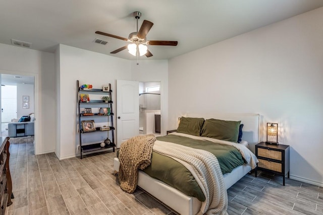 bedroom with baseboards, visible vents, and wood finish floors