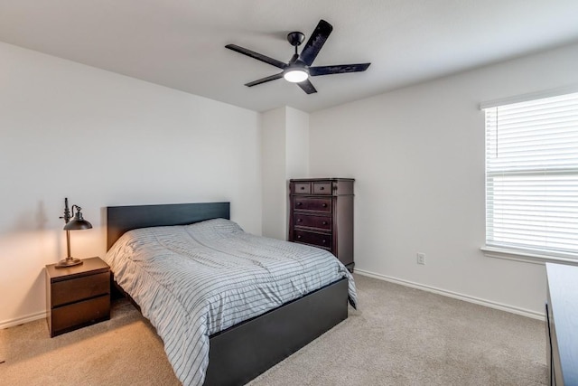 bedroom featuring ceiling fan, light carpet, and baseboards