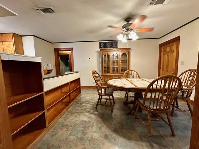 dining area featuring concrete floors, visible vents, a ceiling fan, and baseboards