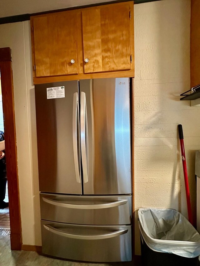 details featuring freestanding refrigerator and brown cabinetry