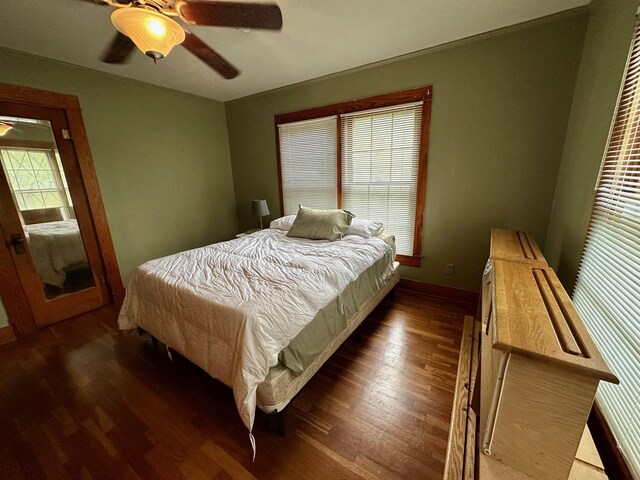 bedroom with a ceiling fan, baseboards, and dark wood-style flooring