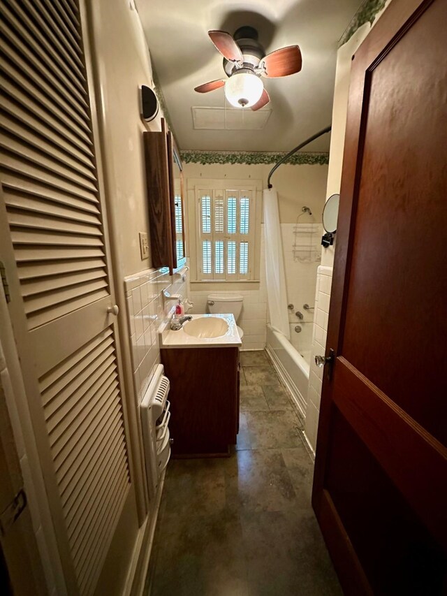 full bathroom with vanity, tile walls, shower / bath combination with curtain, ceiling fan, and toilet