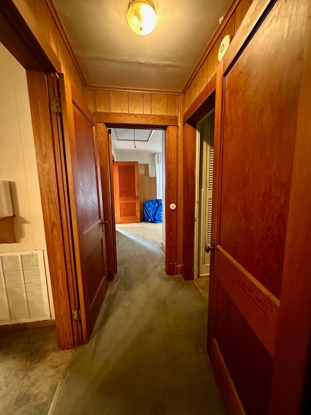 hallway with attic access, carpet, and visible vents
