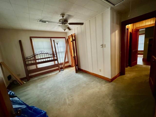 interior space featuring ceiling fan, baseboards, and visible vents