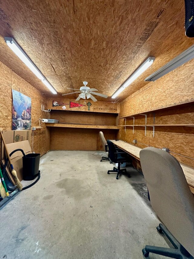 office area featuring unfinished concrete floors and a ceiling fan