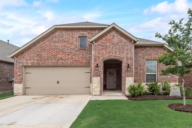 view of front of property featuring roof with shingles, concrete driveway, an attached garage, brick siding, and a front yard
