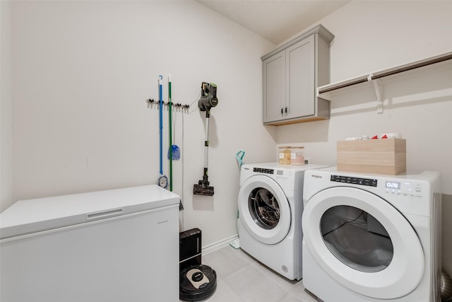 clothes washing area featuring cabinet space, independent washer and dryer, baseboards, and light tile patterned floors