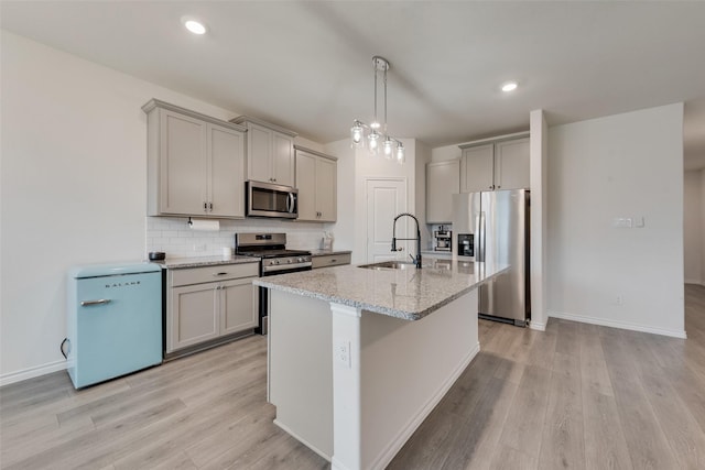 kitchen featuring gray cabinets, stainless steel appliances, light wood-type flooring, and a sink