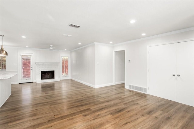 unfurnished living room featuring wood finished floors, visible vents, recessed lighting, and crown molding