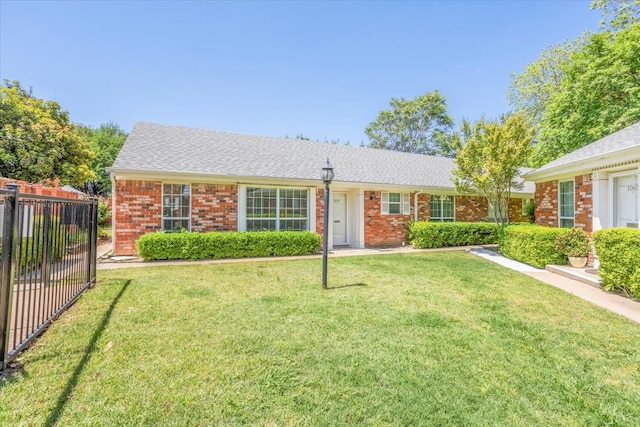 single story home with brick siding, a front lawn, and fence