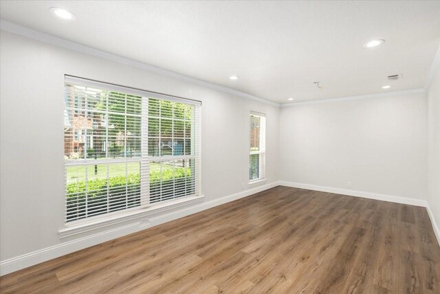 spare room with recessed lighting, wood finished floors, and crown molding