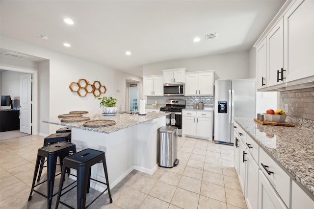 5924 Harvey Gap Ln, Denton, TX 76226 - kitchen featuring appliances with stainless steel finishes, decorative backsplash, a breakfast bar area, light tile patterned flooring, and recessed lighting