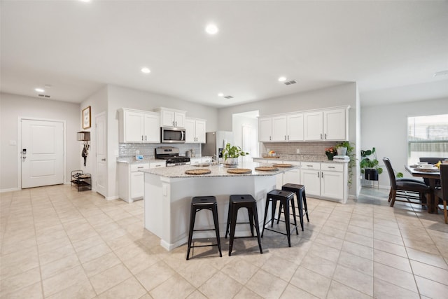 5924 Harvey Gap Ln, Denton, TX 76226 - kitchen with appliances with stainless steel finishes, backsplash, a kitchen island with sink, white cabinets, and recessed lighting