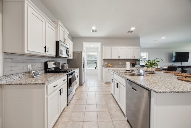5924 Harvey Gap Ln, Denton, TX 76226 - kitchen featuring stainless steel appliances, a sink, backsplash, light tile patterned floors, and plenty of natural light