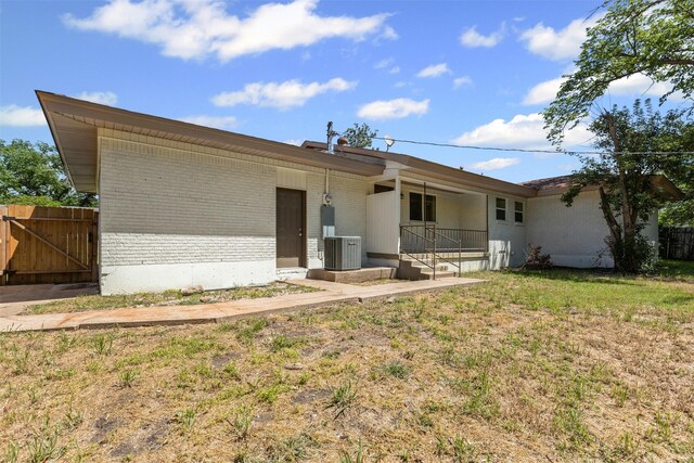 7009 Overhill Rd, Fort Worth, TX 76116 - rear view of house featuring a gate, a lawn, fence, cooling unit, and brick siding