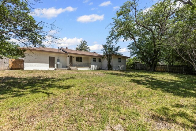 7009 Overhill Rd, Fort Worth, TX 76116 - rear view of house with stucco siding, a lawn, and fence