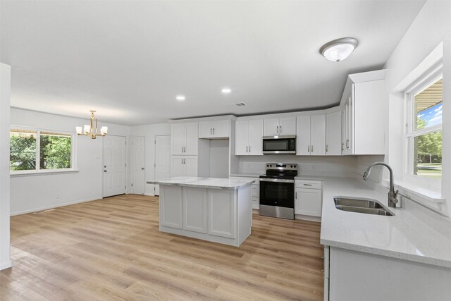 7009 Overhill Rd, Fort Worth, TX 76116 - kitchen featuring an inviting chandelier, appliances with stainless steel finishes, white cabinetry, and a sink