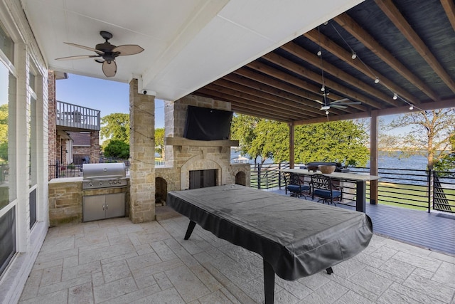 view of patio featuring grilling area, an outdoor stone fireplace, area for grilling, and ceiling fan