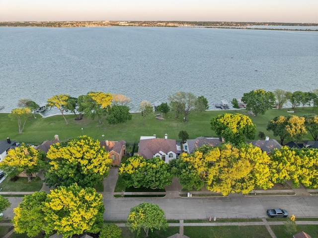 aerial view at dusk featuring a residential view and a water view