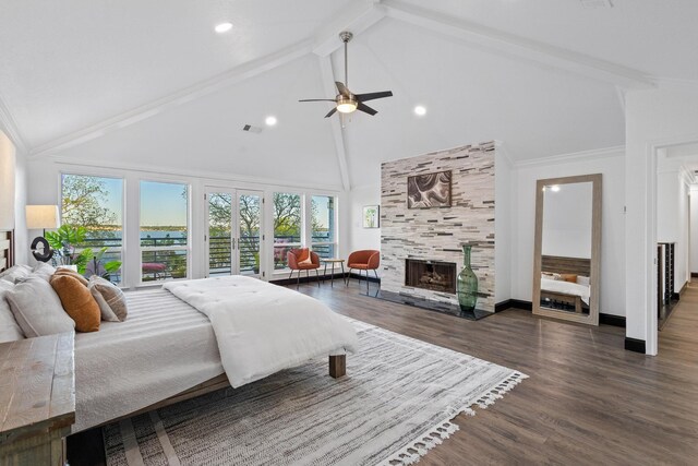 bedroom with wood finished floors, visible vents, beam ceiling, a fireplace, and high vaulted ceiling
