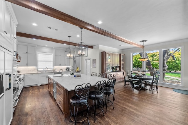 2020 Crown Knoll Ln, Plano, TX 75093 - kitchen featuring plenty of natural light, an island with sink, beamed ceiling, dark wood finished floors, and a sink
