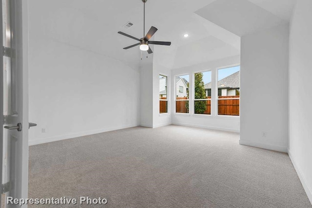 carpeted empty room featuring baseboards, a ceiling fan, visible vents, and lofted ceiling